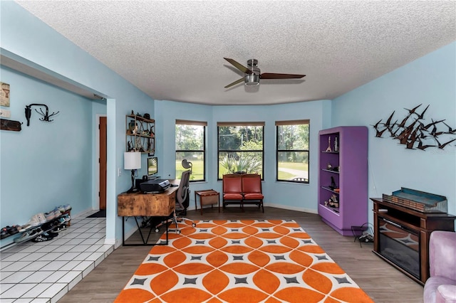 office with wood finished floors, a ceiling fan, and a textured ceiling