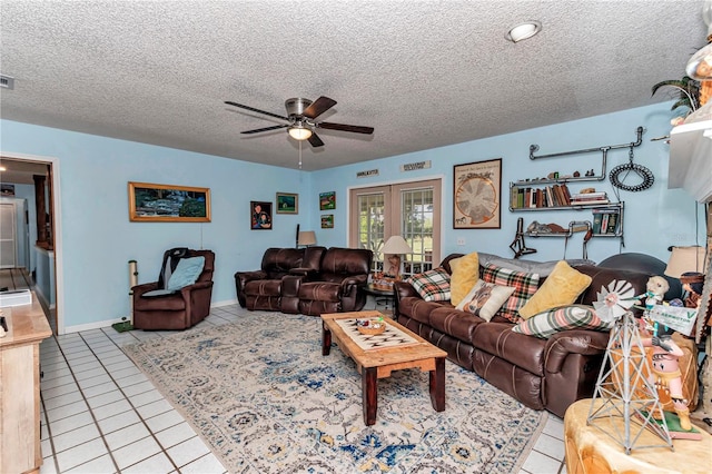 living area with tile patterned flooring, a ceiling fan, and a textured ceiling