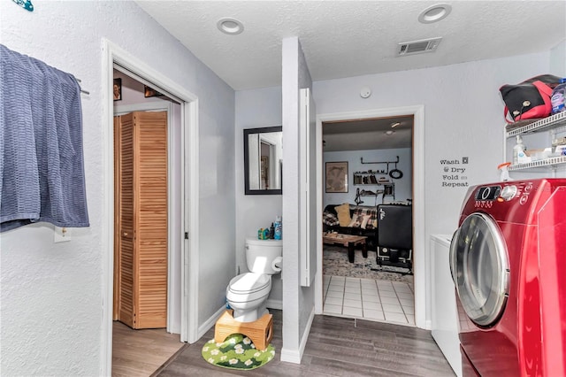laundry room with washer / clothes dryer, wood finished floors, and a textured ceiling