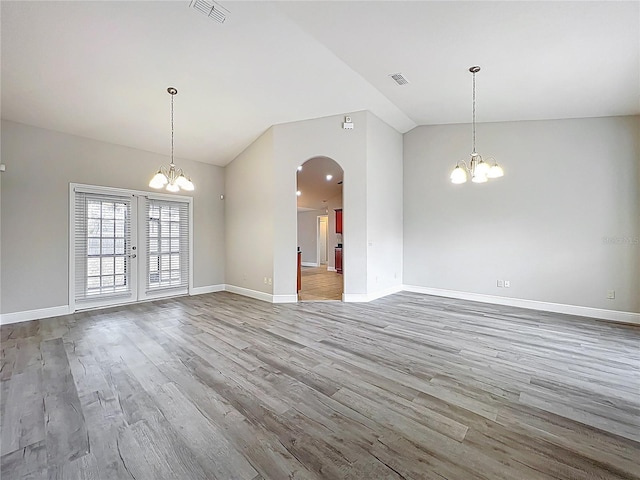interior space featuring arched walkways, lofted ceiling, a chandelier, and visible vents