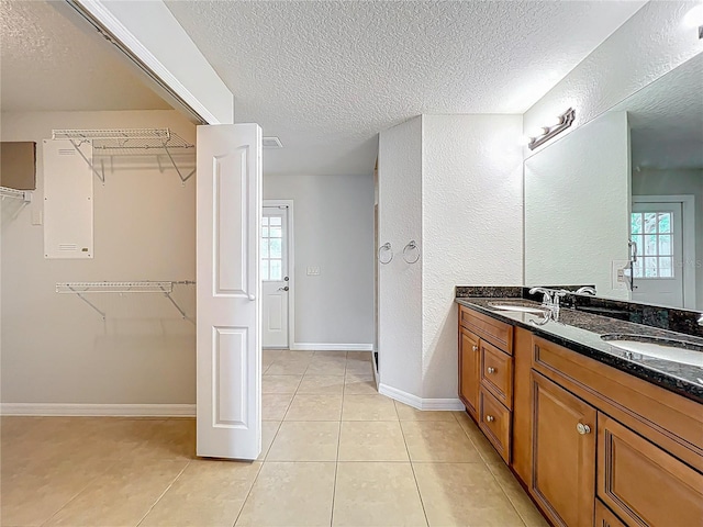 full bathroom with a textured ceiling, a spacious closet, and a sink