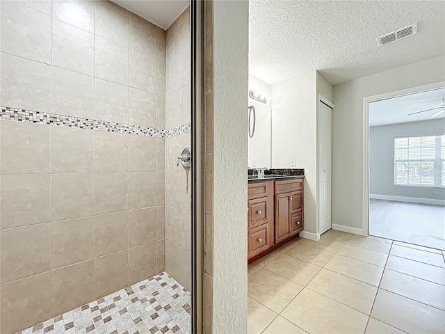 bathroom featuring a stall shower, a textured ceiling, visible vents, tile patterned floors, and vanity