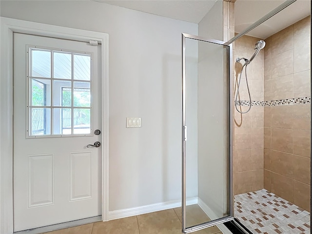 full bathroom with baseboards, tile patterned flooring, and a shower stall