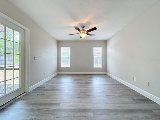 unfurnished room with ceiling fan, baseboards, and wood finished floors