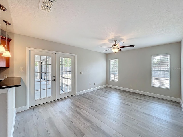 interior space with a healthy amount of sunlight, french doors, and visible vents