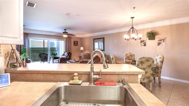 kitchen with light tile patterned floors, a sink, pendant lighting, visible vents, and light countertops
