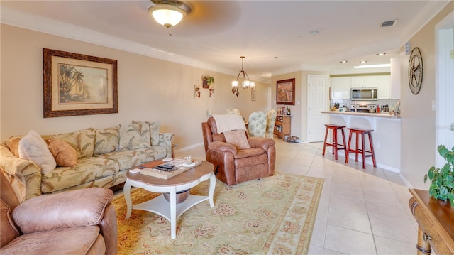 living area with a chandelier, ornamental molding, light tile patterned floors, and visible vents