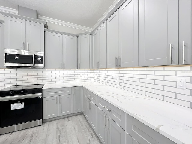 278 Acorn Dr, Longwood, FL 32750 - kitchen with electric range oven, gray cabinets, stainless steel microwave, light stone countertops, and light wood-style floors