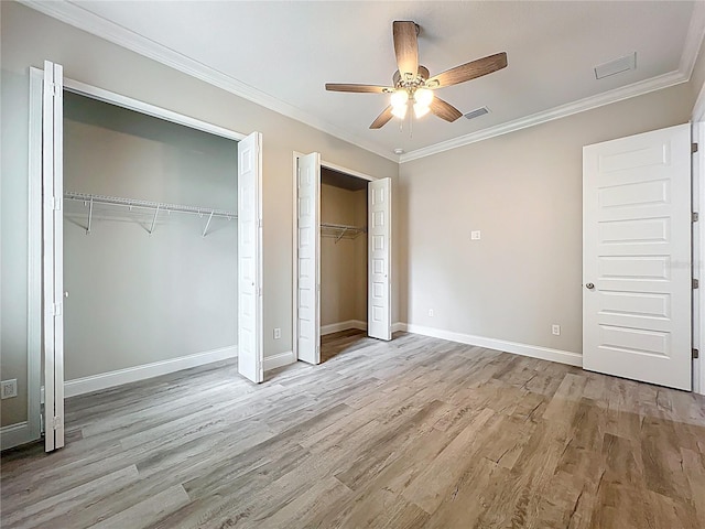278 Acorn Dr, Longwood, FL 32750 - unfurnished bedroom featuring crown molding, two closets, visible vents, and wood finished floors