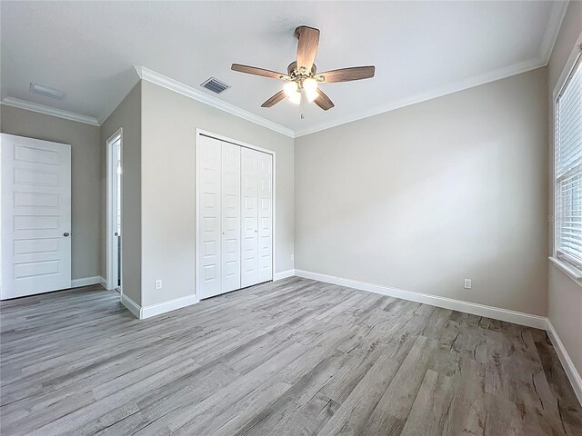 278 Acorn Dr, Longwood, FL 32750 - unfurnished bedroom with a closet, light wood-style flooring, baseboards, ornamental molding, and visible vents