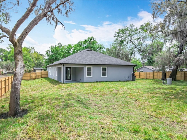 278 Acorn Dr, Longwood, FL 32750 - back of house featuring a yard, stucco siding, roof with shingles, and a fenced backyard