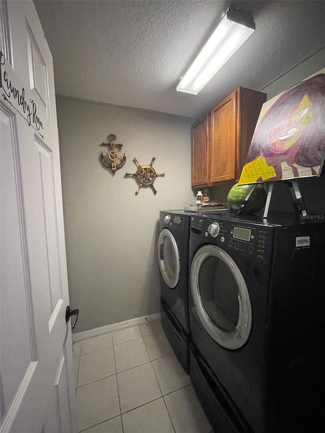 447 Cadiz Loop, Davenport, FL 33837 - laundry room with cabinet space, light tile patterned flooring, a textured ceiling, washing machine and clothes dryer, and baseboards