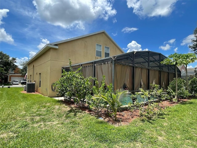 447 Cadiz Loop, Davenport, FL 33837 - view of side of home with a yard, stucco siding, and central AC