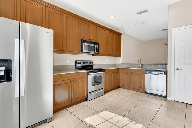 2975 White Cedar Cir, Kissimmee, FL 34741 - kitchen with appliances with stainless steel finishes, light countertops, brown cabinets, and recessed lighting