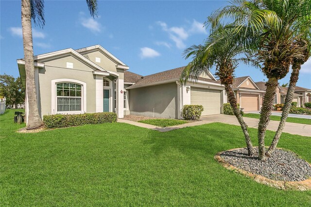 2975 White Cedar Cir, Kissimmee, FL 34741 - view of front of house featuring a garage, concrete driveway, a front lawn, and stucco siding