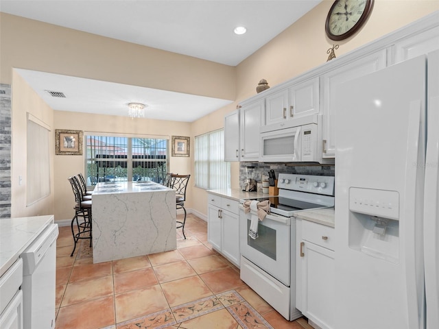 kitchen featuring white cabinetry, visible vents, white appliances, decorative backsplash, and light tile patterned flooring