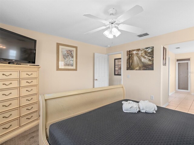 bedroom with light colored carpet, visible vents, ceiling fan, light tile patterned floors, and baseboards
