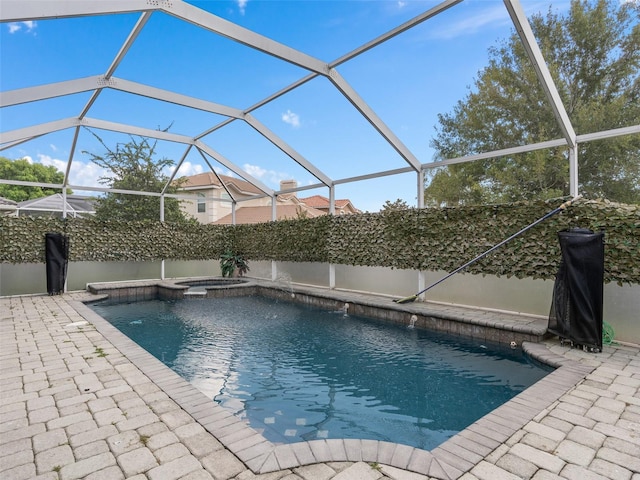 view of pool featuring a patio, a pool with connected hot tub, and a lanai
