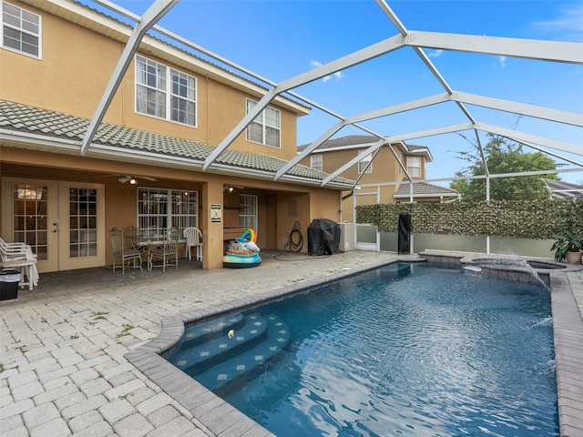 view of pool with a patio area, french doors, glass enclosure, a fenced in pool, and an in ground hot tub