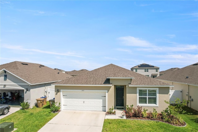 1975 Cacutta Way, Kissimmee, FL 34744 - view of front facade featuring roof with shingles, a garage, driveway, and stucco siding