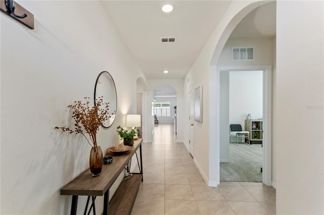 1975 Cacutta Way, Kissimmee, FL 34744 - hall featuring light tile patterned flooring, arched walkways, recessed lighting, baseboards, and light colored carpet
