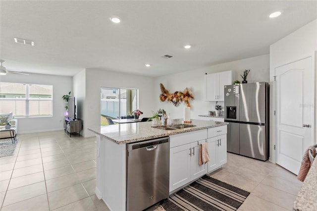 1975 Cacutta Way, Kissimmee, FL 34744 - kitchen with appliances with stainless steel finishes, a sink, light stone counters, white cabinets, and light tile patterned flooring