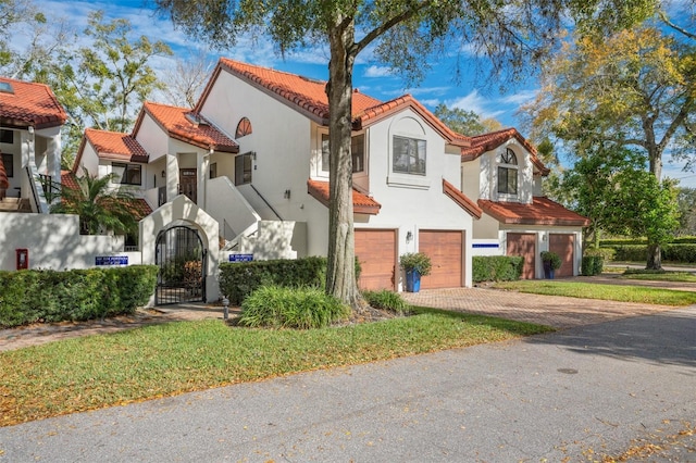 546 Via Fontana Dr Unit 203, Altamonte Springs, FL 32714 - mediterranean / spanish-style house featuring driveway, a garage, stucco siding, a tile roof, and a gate