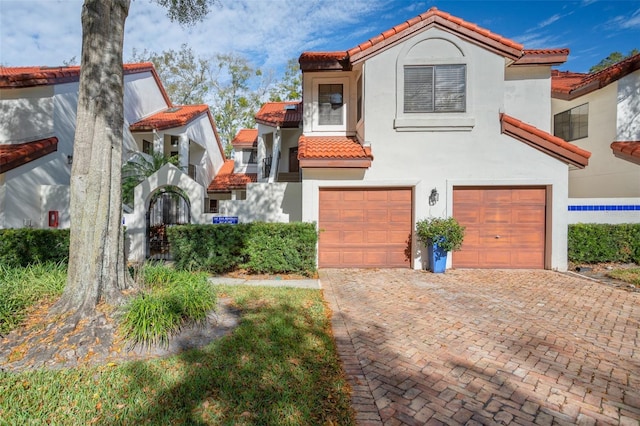 546 Via Fontana Dr Unit 203, Altamonte Springs, FL 32714 - mediterranean / spanish home featuring an attached garage, a tiled roof, stucco siding, and decorative driveway
