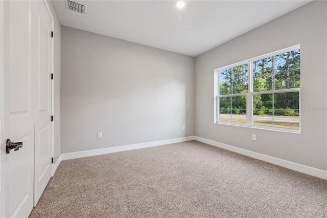 unfurnished room featuring carpet floors and baseboards