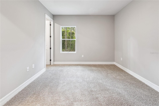 empty room featuring carpet floors and baseboards