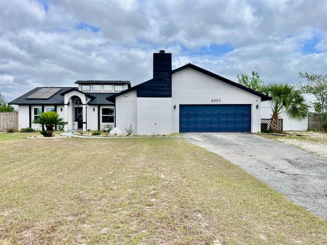 6653 SE 87th St, Ocala, FL 34472 - view of front of house featuring asphalt driveway, a garage, a chimney, and stucco siding