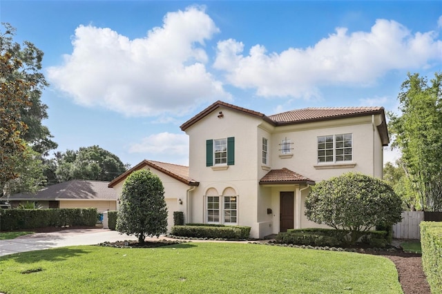 mediterranean / spanish-style house with a tiled roof, stucco siding, concrete driveway, and a garage
