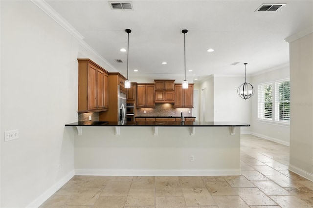 kitchen featuring brown cabinets, ornamental molding, backsplash, baseboards, and a kitchen bar