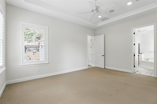 unfurnished bedroom featuring carpet, a tray ceiling, recessed lighting, baseboards, and ensuite bathroom