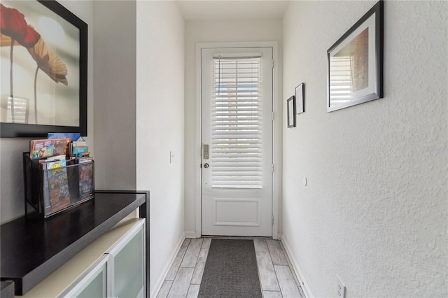 7663 Fitzclarence St, Kissimmee, FL 34747 - entryway with baseboards, wood tiled floors, and a textured wall