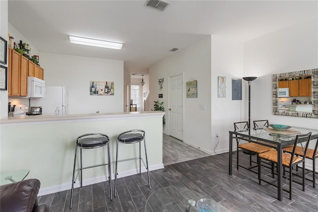 7663 Fitzclarence St, Kissimmee, FL 34747 - kitchen with white appliances, dark wood-style flooring, brown cabinets, and a peninsula
