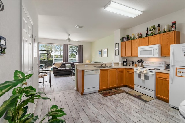 7663 Fitzclarence St, Kissimmee, FL 34747 - kitchen featuring white appliances, a peninsula, open floor plan, a sink, and wood tiled floors