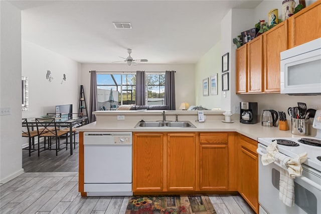 7663 Fitzclarence St, Kissimmee, FL 34747 - kitchen featuring white appliances, a sink, a peninsula, light countertops, and ceiling fan
