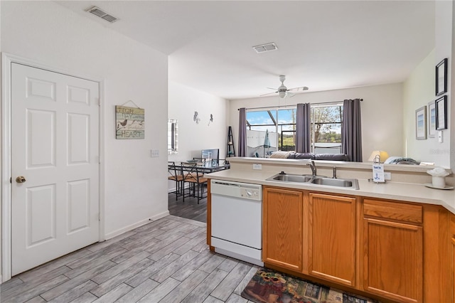 7663 Fitzclarence St, Kissimmee, FL 34747 - kitchen with dishwasher, a sink, light wood-style flooring, light countertops, and open floor plan