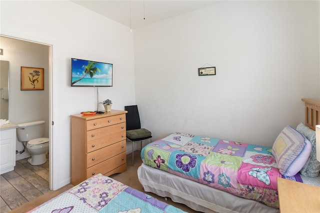 7663 Fitzclarence St, Kissimmee, FL 34747 - bedroom with connected bathroom and light wood-style flooring