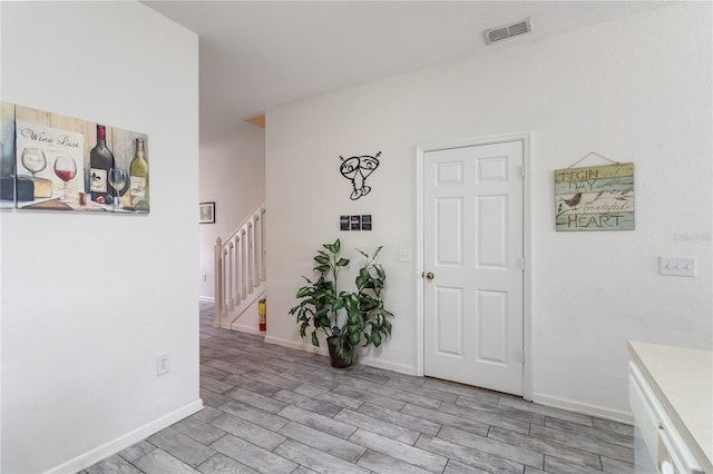 7663 Fitzclarence St, Kissimmee, FL 34747 - hall featuring stairway, wood tiled floors, and baseboards