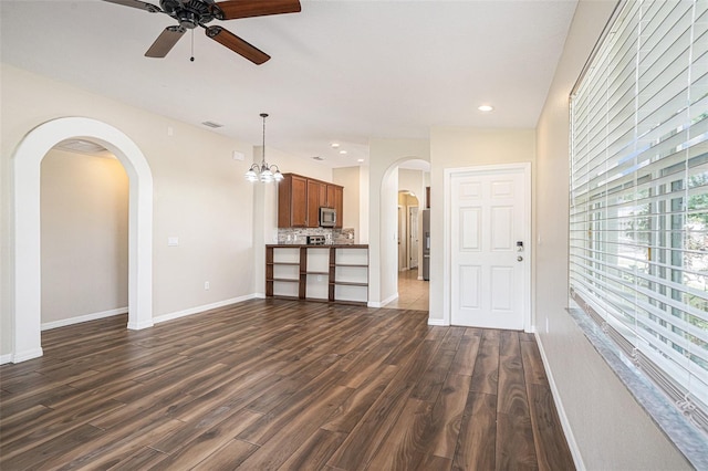 3319 Thistledown Ln, Land O Lakes, FL 34638 - unfurnished living room featuring dark wood-style floors, ceiling fan, arched walkways, baseboards, and recessed lighting