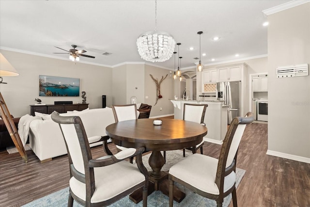 dining space with ornamental molding, ceiling fan with notable chandelier, and dark wood finished floors