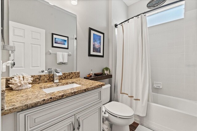full bathroom featuring shower / tub combo with curtain, vanity, and toilet