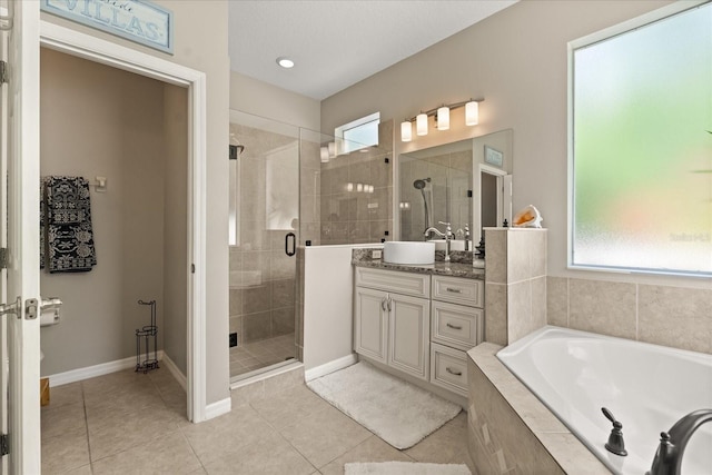 full bath with a garden tub, tile patterned floors, baseboards, a shower stall, and vanity