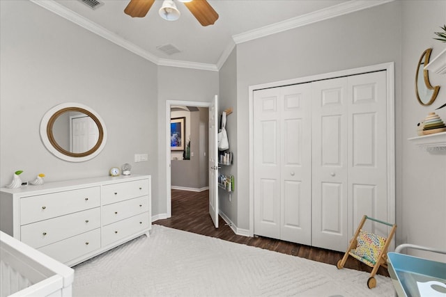 bedroom featuring a closet, baseboards, visible vents, crown molding, and wood finished floors