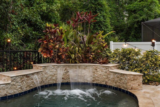 view of pool featuring an in-ground hot tub, fence, and a lanai