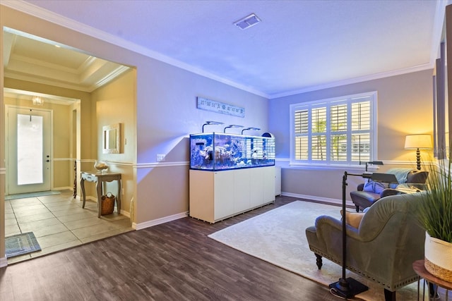 living area with crown molding, baseboards, and wood finished floors