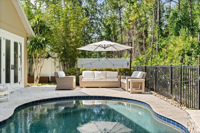 view of swimming pool featuring french doors, a patio area, a fenced backyard, and outdoor lounge area