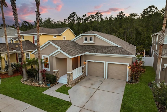 view of front of home featuring stucco siding, a shingled roof, driveway, and a garage